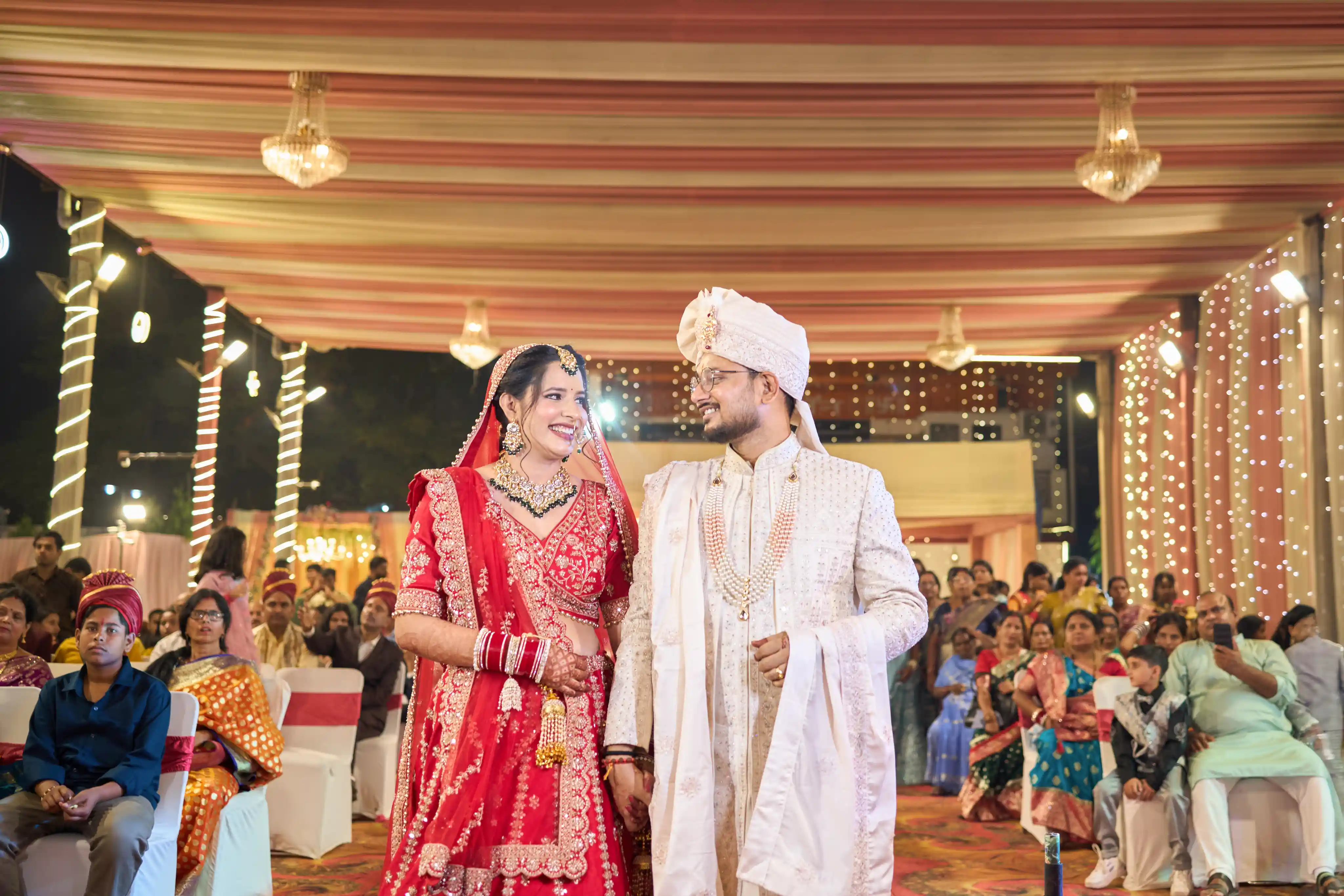 Bride and groom forehead touch in the golden floral walkway at Chaudhary Lawn Varanasi by The WeddingShoot